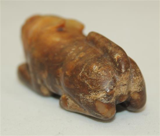 A Chinese celadon and brown jade figure of a recumbent lion-dog, Song dynasty or later, 5.7cm